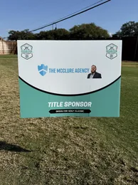 Letrero de patrocinio de The McClure Agency en el torneo de golf